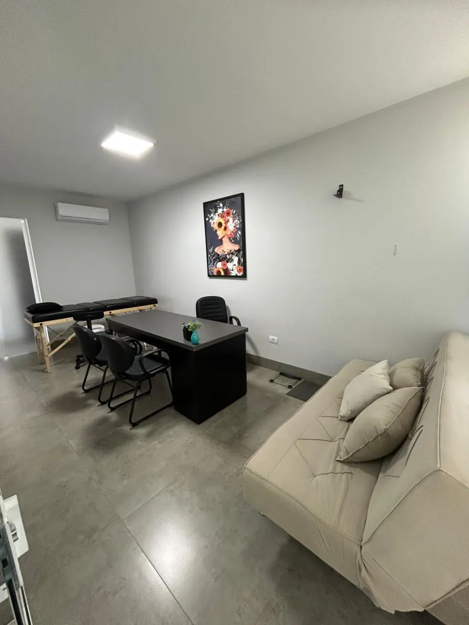 Sala de atendimento com mesa e sofá
